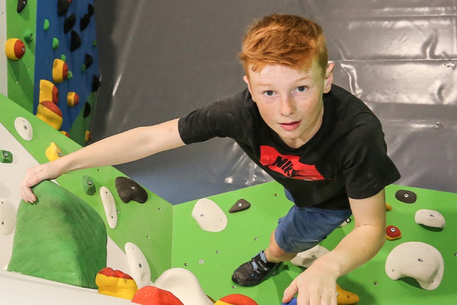 glückliches Kind im Kinderboulderraum